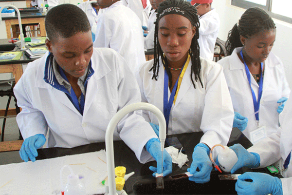 Two teen girls prep a microscope slide