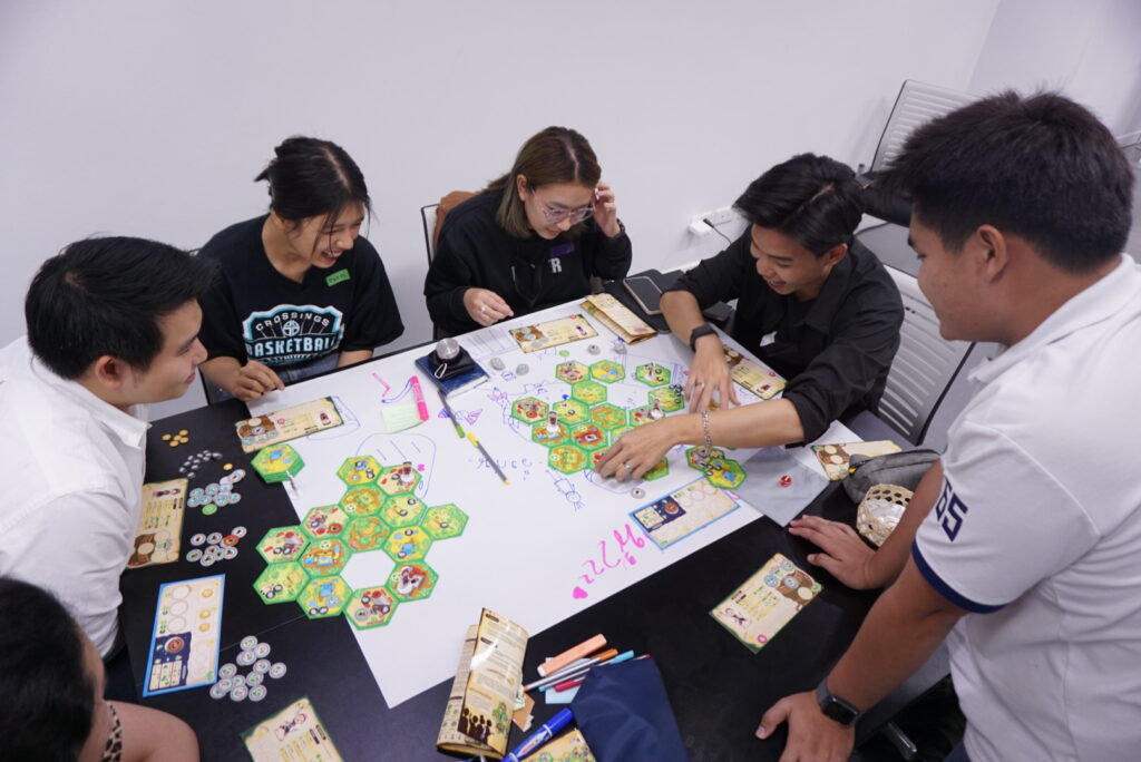 Six young people playing a board game together at a table.